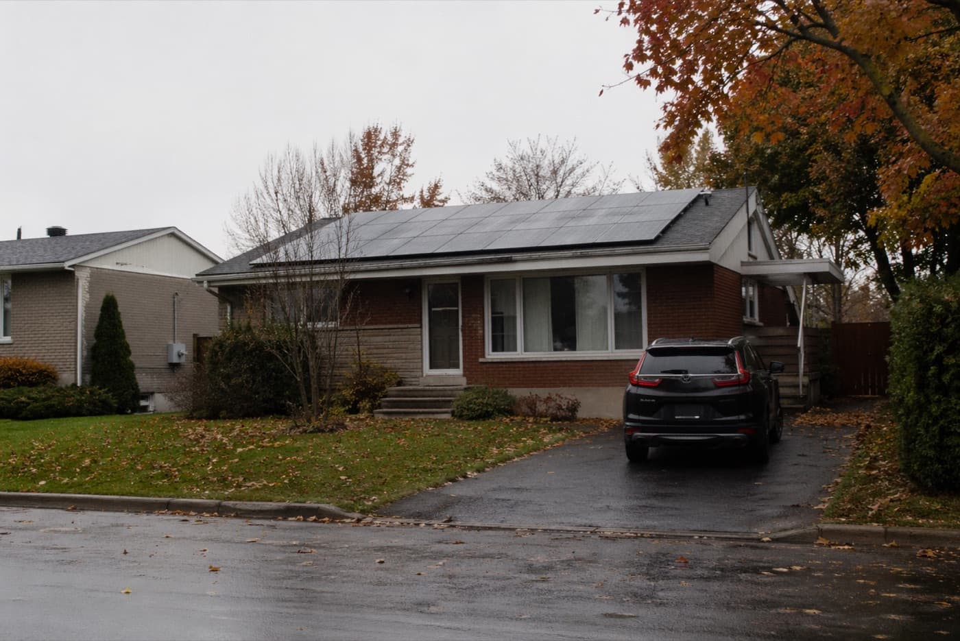 Bungalow brique avec panneaux solaires en automne, Rive-Sud