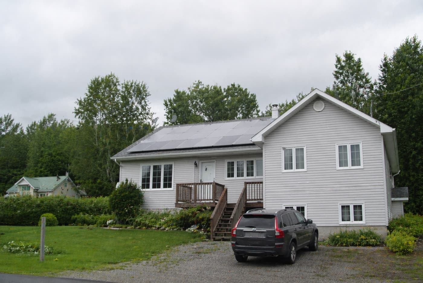 Maison en région avec panneaux solaires en été, Québec